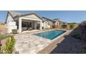 Backyard featuring a sparkling pool and a neutral colored patio with outdoor grill and seating at 8043 E Jaeger St, Mesa, AZ 85207