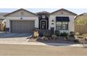 Charming single-story home featuring desert landscaping, a two-car garage, and a welcoming front entrance with black awning at 8043 E Jaeger St, Mesa, AZ 85207
