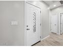 Elegant white front door with decorative glass, complemented by neutral walls and tile flooring at 9460 W Hartigan Ln, Arizona City, AZ 85123