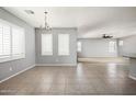 A bright living room with tile flooring and multiple windows with plantation shutters allowing ample sunlight at 1170 E Taylor Trl, San Tan Valley, AZ 85143