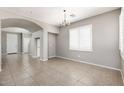 A bright living room with tile flooring, neutral walls, a chandelier, and a door to another room at 1170 E Taylor Trl, San Tan Valley, AZ 85143