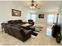 Spacious living room boasts vaulted ceilings, tile floors, and comfortable leather seating at 12008 W Acapulco Dr, El Mirage, AZ 85335