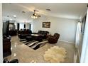 Expansive living room featuring tile floors, recessed lighting, and plush leather furniture at 12008 W Acapulco Dr, El Mirage, AZ 85335