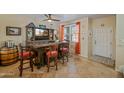 Cozy living room featuring a custom bar, tile flooring, and ample natural light at 2315 E Pecan Rd, Phoenix, AZ 85040