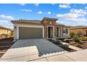 Beautifully landscaped front yard with a stone accent facade and a spacious driveway leading to a two-car garage at 26635 W Covey Ln, Buckeye, AZ 85396