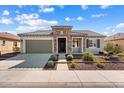 Charming single-story home featuring a stone facade, well-maintained landscaping, and a two-car garage at 26635 W Covey Ln, Buckeye, AZ 85396