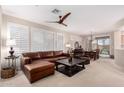 Inviting living room with a leather sectional, a ceiling fan, and natural light at 2951 W Plum Hollow Dr, Anthem, AZ 85086
