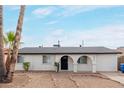 Charming single-story home featuring desert landscaping and an arched entryway at 3217 E Friess Dr, Phoenix, AZ 85032