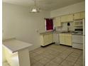 A bright kitchen with tiled floor, white appliances and yellow cabinets at 349 E Thomas Rd # E402, Phoenix, AZ 85012