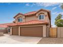 A well-maintained house with a three-car garage and a red tile roof at 4129 E Nighthawk Way, Phoenix, AZ 85048