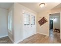 Entryway of the house with double white doors and light wood flooring at 4325 E Sacaton St, Phoenix, AZ 85044