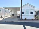 Charming mobile home with a spacious carport, well-maintained landscaping, and appealing exterior at 455 S Jaspar Dr, Apache Junction, AZ 85119