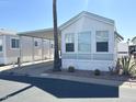 Charming mobile home with a covered carport, desert landscaping, and welcoming front at 455 S Jaspar Dr, Apache Junction, AZ 85119