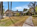 Charming single-story home with mature trees and a lush green lawn at 5112 N 41St St, Phoenix, AZ 85018