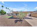 Inviting home featuring low maintenance desert landscaping, a carport, and a cozy front patio at 6943 E Granada Rd, Scottsdale, AZ 85257