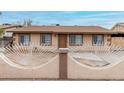 Single-story home boasting a quaint front yard enclosed by a unique decorative metal and masonry fence at 7017 W Beatrice St, Phoenix, AZ 85043