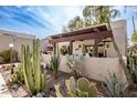 Inviting front patio area with a wooden pergola and a variety of desert plants in a serene setting at 7920 E Via Camello -- # 48, Scottsdale, AZ 85258