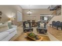 Inviting living area showcasing neutral decor, an open staircase, and an adjoining dining room at 8761 W Mary Ann Dr, Peoria, AZ 85382