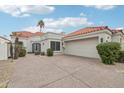 Charming home with a spacious driveway, two-car garage, terracotta roof and desert landscaping at 9155 N 107Th St, Scottsdale, AZ 85258