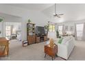 Comfortable living room with a ceiling fan, TV, shelving, and an adjacent room with a bed at 9922 E Onza Ave, Mesa, AZ 85212