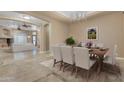 Formal dining room featuring a table set for six with an elegant chandelier overhead and view to the living room at 10931 S Santa Columbia Dr, Goodyear, AZ 85338