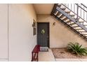 Cozy entry featuring a gray front door, a bench, exterior stairs, and decorative landscaping at 14145 N 92Nd St # 1031, Scottsdale, AZ 85260