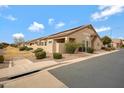 A landscaped exterior view showcasing multiple attached single-story homes with neutral color palette and street view at 1589 E Manor Dr, Casa Grande, AZ 85122