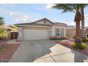 Charming single-story home with a two-car garage, desert landscaping, and a mature palm tree at 15911 W Carmen Dr, Surprise, AZ 85374