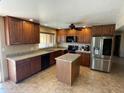 Well-lit kitchen with dark wood cabinets, granite countertops, stainless steel appliances, and a central island at 16423 N 41St Pl, Phoenix, AZ 85032