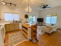 Open-concept living room showcases tile floors, a kitchen island, a dining area and a comfortable seating area at 16545 E Gunsight Dr # 103, Fountain Hills, AZ 85268