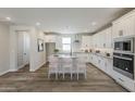 Modern kitchen features white cabinets, an island with seating, stainless steel appliances and hardwood style flooring at 2121 W Sonoran Desert Dr # 45, Phoenix, AZ 85085