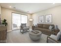 Well-lit living room features neutral paint, carpet, modern furniture and a sliding glass door to the balcony at 2121 W Sonoran Desert Dr # 45, Phoenix, AZ 85085