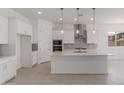 Bright open concept kitchen with a large island, stainless steel appliances, and modern pendant lights at 21640 E Roundup Way, Queen Creek, AZ 85142