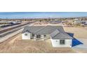 A charming single-story home with a gray tiled roof sits on a large lot ready for landscaping at 30634 W Latham St, Buckeye, AZ 85326