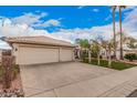 Spacious three car garage with neutral paint and tile roof, surrounded by mature palm trees and lush green grass at 3431 E Kristal Way, Phoenix, AZ 85050