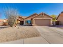 Charming home featuring desert landscaping, a two-car garage, and welcoming covered porch under clear blue skies at 4044 E Cascalote Dr, Cave Creek, AZ 85331