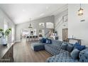 Open concept living space with hardwood flooring, vaulted ceiling, and a custom blue velvet sofa at 4805 E Monte Cristo Ave, Scottsdale, AZ 85254