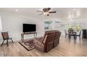 Comfortable living room with wood-look floors, a ceiling fan, and seamless access to the dining and kitchen areas at 6224 E Decatur St, Mesa, AZ 85205