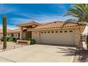 Single-story home with a red tile roof, desert landscaping, and an attached two car garage and private drive at 8303 E Monterey Ave, Mesa, AZ 85209