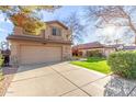 Beige two-story home with two-car garage, green grass, and desert landscaping at 1043 W Washington Ave, Gilbert, AZ 85233