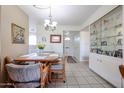 Inviting dining room featuring a table set for four and a decorative display cabinet at 10846 N Fairway E Ct, Sun City, AZ 85351