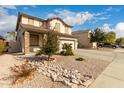 Charming two-story home showcasing stone accents, a two-car garage, and low-maintenance landscaping at 11128 E Segura Ave, Mesa, AZ 85212