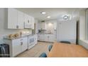 Well-lit kitchen with modern white cabinets, tile flooring, and white appliances at 11407 N 111Th Ave, Sun City, AZ 85351