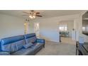 Open-concept living room featuring plush carpet and comfortable blue couch at 11407 N 111Th Ave, Sun City, AZ 85351