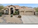 Elegant home featuring a landscaped front yard, a spacious three-car garage, and a tile roof at 12610 E Cortez Dr, Scottsdale, AZ 85259