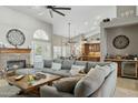 A spacious living room featuring a stone fireplace, large windows, and seamless flow into the kitchen at 12610 E Cortez Dr, Scottsdale, AZ 85259