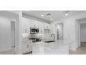 Bright, modern kitchen features white cabinetry, stainless steel appliances, and a sleek island at 16778 W Yucatan Dr, Surprise, AZ 85378