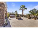 Spacious backyard features palm trees, desert plants, and a built-in fire pit at 17634 W Verdin Rd, Goodyear, AZ 85338