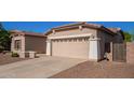 Beige two-car garage with white columns, exterior lantern sconces, and a large driveway at 18750 E Ryan Rd, Queen Creek, AZ 85142