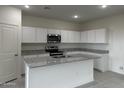 Stylish kitchen with granite countertops, white cabinets, and stainless steel appliances at 2076 E Bucking Bronco Dr, San Tan Valley, AZ 85140